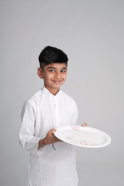 Portrait de garçon souriant tenant une assiette vide dans les mains