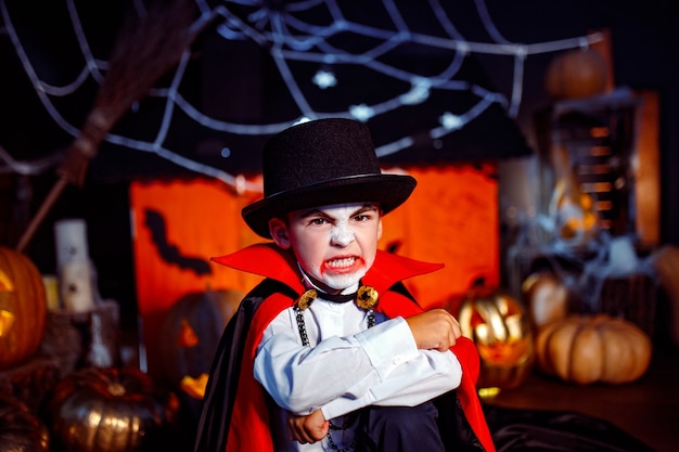 Portrait d'un garçon vêtu d'un costume de vampire sur fond grunge. Fête d'Halloween.