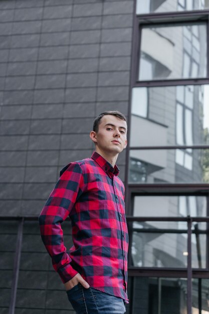 Portrait d'un gars dans une chemise à carreaux rouge