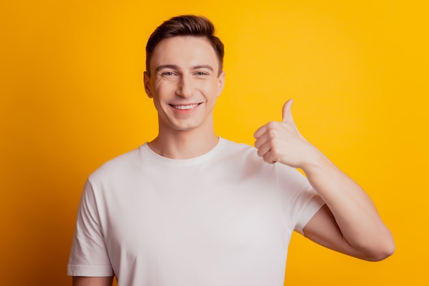 Portrait de gars fiable lever le pouce vers le haut sourire brillant visage positif sur fond jaune