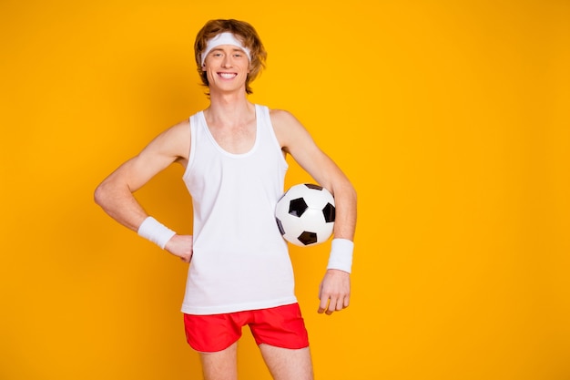 Photo portrait de gars sportif tenant dans la main un ballon de football