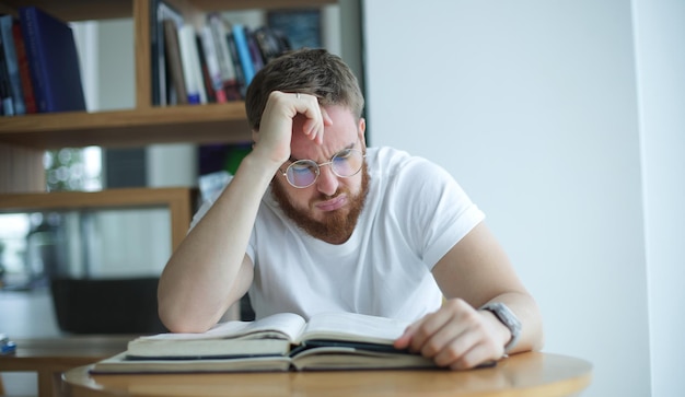 Portrait d'un gars surmené fatigué épuisé jeune homme à lunettes étudiant universitaire ou collégial est