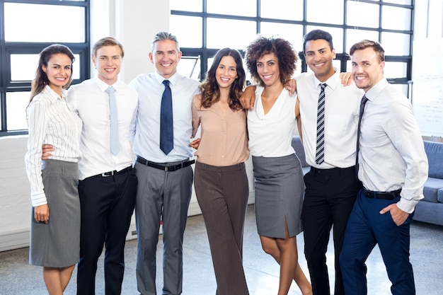 Portrait de gens d&#39;affaires debout ensemble et souriant au bureau