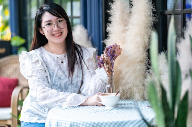 Photo portrait de gens asiatiques heureux et attrayants une femme mignonne qui sent des fleurs violettes un bouquet