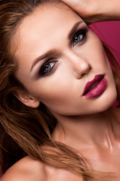 Portrait glamour du modèle belle femme avec du maquillage frais et une coiffure ondulée romantique.