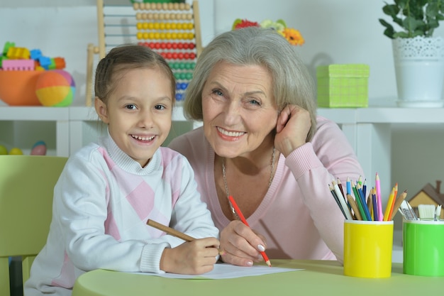 Portrait d'une grand-mère heureuse avec sa petite-fille réunissant