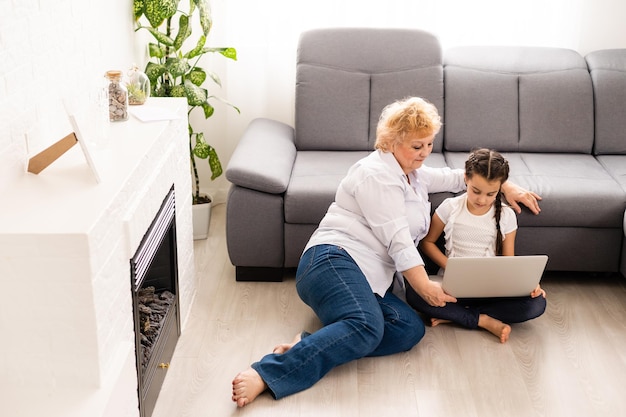 Portrait de grand-mère et petite-fille shopping en ligne ensemble à la maison.