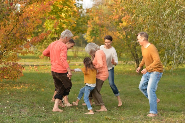 Portrait d'une grande famille heureuse jouant au football dans le parc