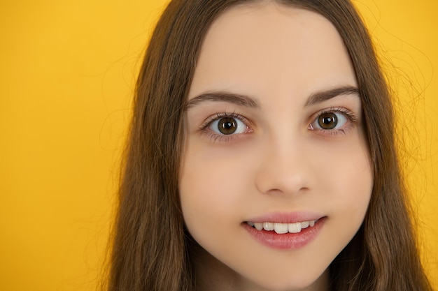 Photo portrait en gros plan d'une adolescente caucasienne coup de tête d'un enfant adolescent mignon sur fond de studio isolé jaune