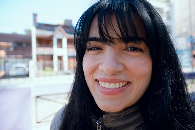 portrait en gros plan en angle d'une jeune femme latine souriante regardant l'espace de copie de l'appareil photo