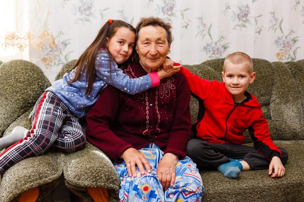 Portrait en gros plan d'une arrière-grand-mère heureuse avec des arrière-petits-enfants sur le canapé à la maison