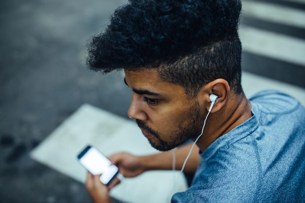 Portrait en gros plan d'un athlète écoutant de la musique et utilisant un téléphone portable