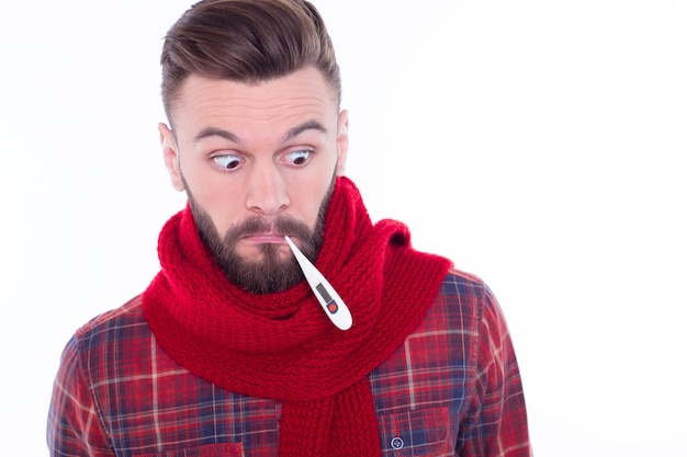 Portrait en gros plan d'un bel homme barbu avec une serviette regardant son reflet dans le miroir de la salle de bain isolé sur fond blanc