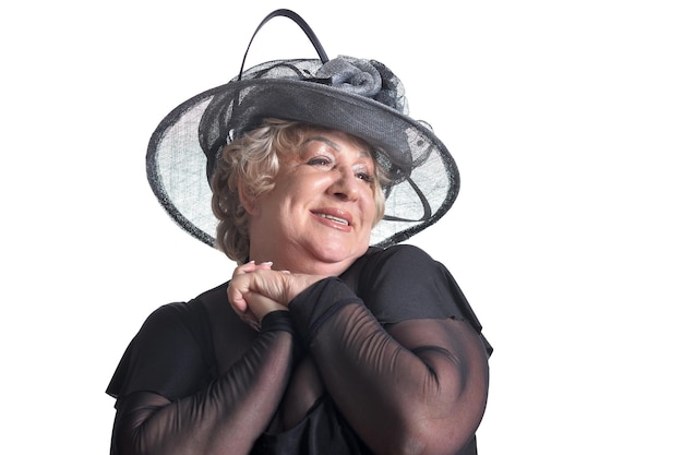 Portrait en gros plan d'une belle femme âgée au chapeau posant sur fond blanc