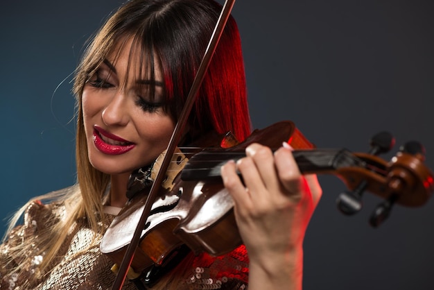 Portrait en gros plan d'une belle jeune femme jouant du violon