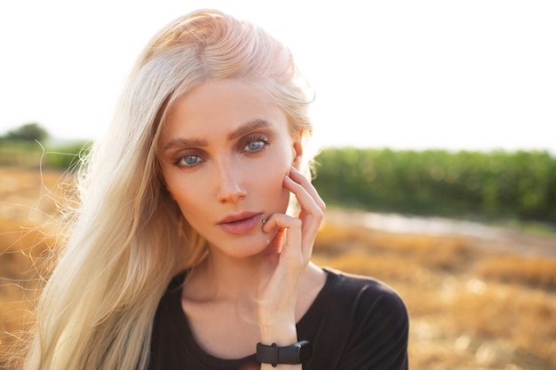 Portrait en gros plan de la belle jeune fille blonde dans le champ de blé.