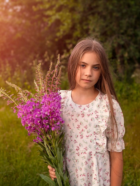 portrait en gros plan d'une belle petite fille avec un bouquet de fleurs