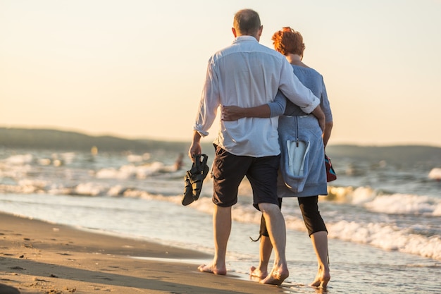 Portrait en gros plan d'un couple de personnes âgées étreignant sur la côte