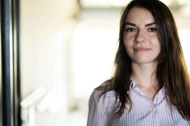 Portrait en gros plan du visage d'une belle jeune femme brune en chemise