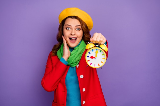 Portrait en gros plan d'elle elle jolie jolie jolie jolie charmante joyeuse joyeuse étonnée fille aux cheveux ondulés montrant une horloge enfantine isolée sur fond de couleur pastel violet lilas violet