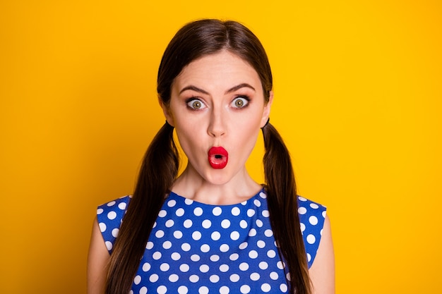 Portrait en gros plan d'elle, elle, jolie, séduisante, jolie fille étonnée glamour portant un chemisier à pois bleus moue lèvres réaction isolée sur fond de couleur jaune vif éclatant