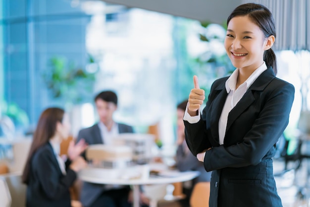 Portrait en gros plan d'une femme d'affaires asiatique attrayante et intelligente souriante avec confiance et leadership dans un bureau moderne