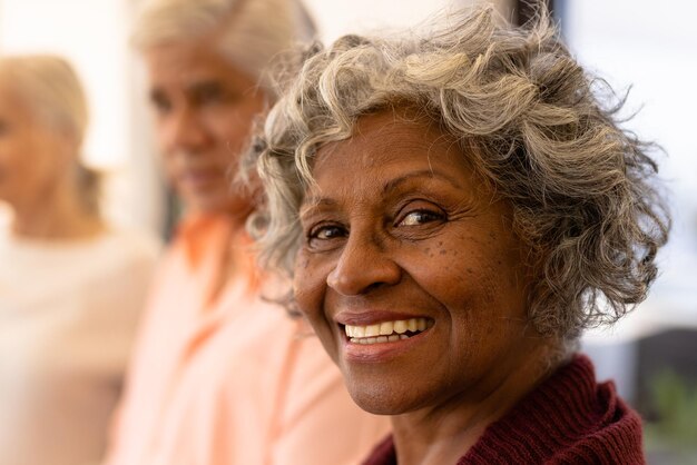 Photo portrait en gros plan d'une femme âgée afro-américaine joyeuse avec des amis multiraciaux dans une maison de retraite. concept heureux, inchangé, d'amitié, de convivialité, de soutien, de vie assistée et de retraite.