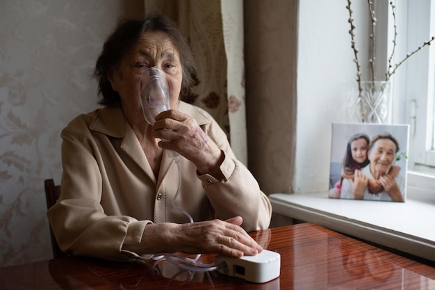 portrait en gros plan d'une femme âgée faisant l'inhalation.