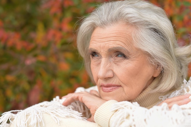 Portrait en gros plan d'une femme âgée triste dans un parc d'automne