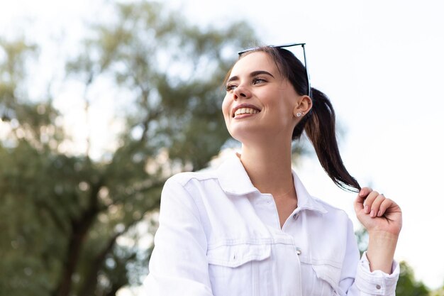 Portrait en gros plan d'une femme caucasienne souriante aux dents blanches regardant de côté