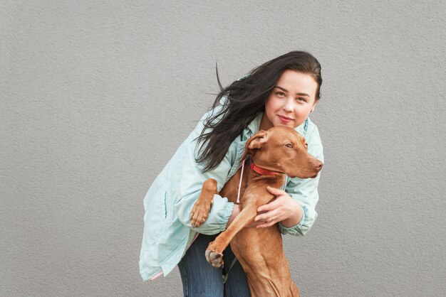 Portrait en gros plan d'une femme embrasse un chien