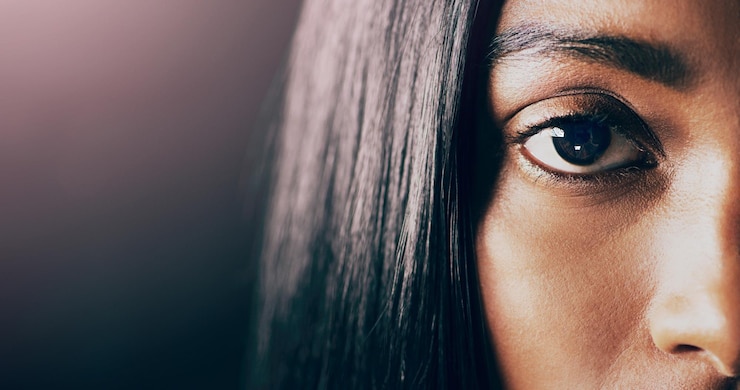 Photo portrait en gros plan et femme avec une maquette des yeux et de la santé sur un fond de studio sombre visage de femme et modèle avec rétine de mise au point et vision claire avec cils de sourcils et microblading