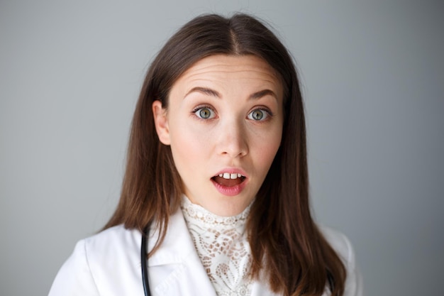 Portrait en gros plan d'une femme médecin sur fond gris