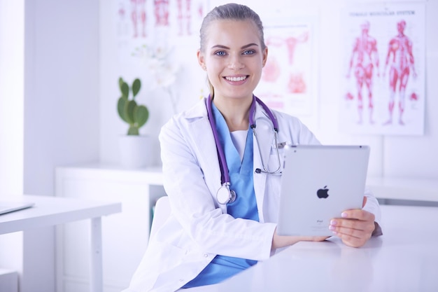 Portrait en gros plan d'une femme médecin sympathique avec stéthoscope et tablette dans les mains