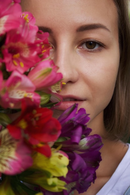 Portrait en gros plan d'une femme par des fleurs