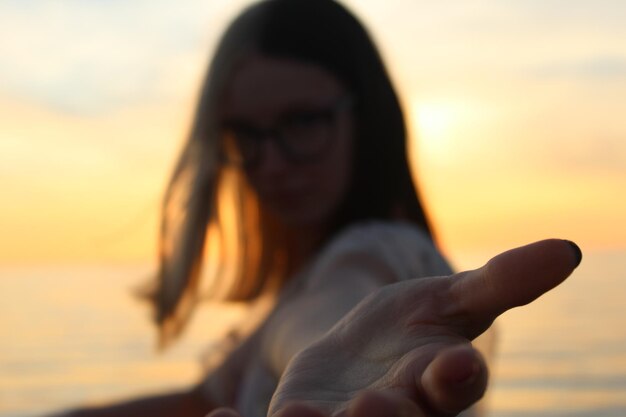 Photo portrait en gros plan d'une femme sur la plage au coucher du soleil