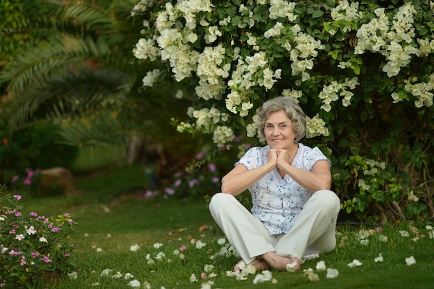 Portrait en gros plan d'une femme plus âgée en promenade avec des fleurs