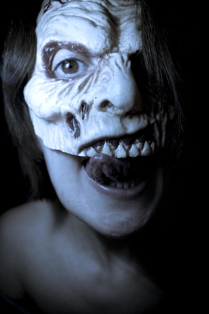 Portrait en gros plan d'une femme sans chemise portant un masque effrayant