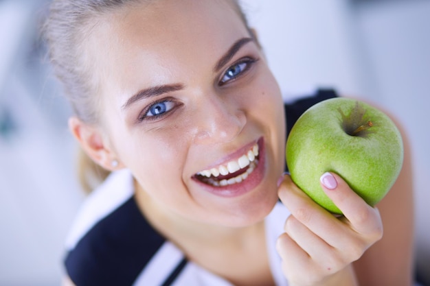 Portrait en gros plan d'une femme souriante en bonne santé avec pomme verte