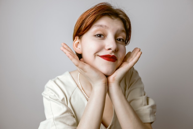 Portrait en gros plan de femmes aux lèvres rouges touchant le visage et souriant