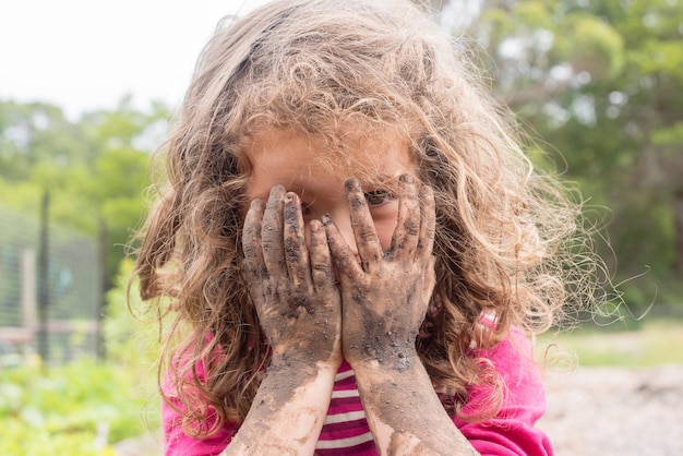 Photo portrait en gros plan d'une fille aux mains sales