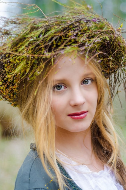 Portrait en gros plan d'une fille dans un style médiéval folklorique avec un cercle de fleurs