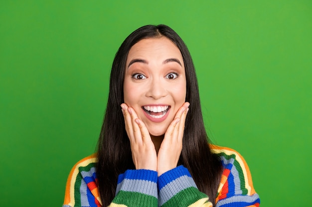 Portrait en gros plan d'une fille joyeuse ravie et étonnée profitant d'une excellente nouvelle isolée sur fond de couleur vert clair