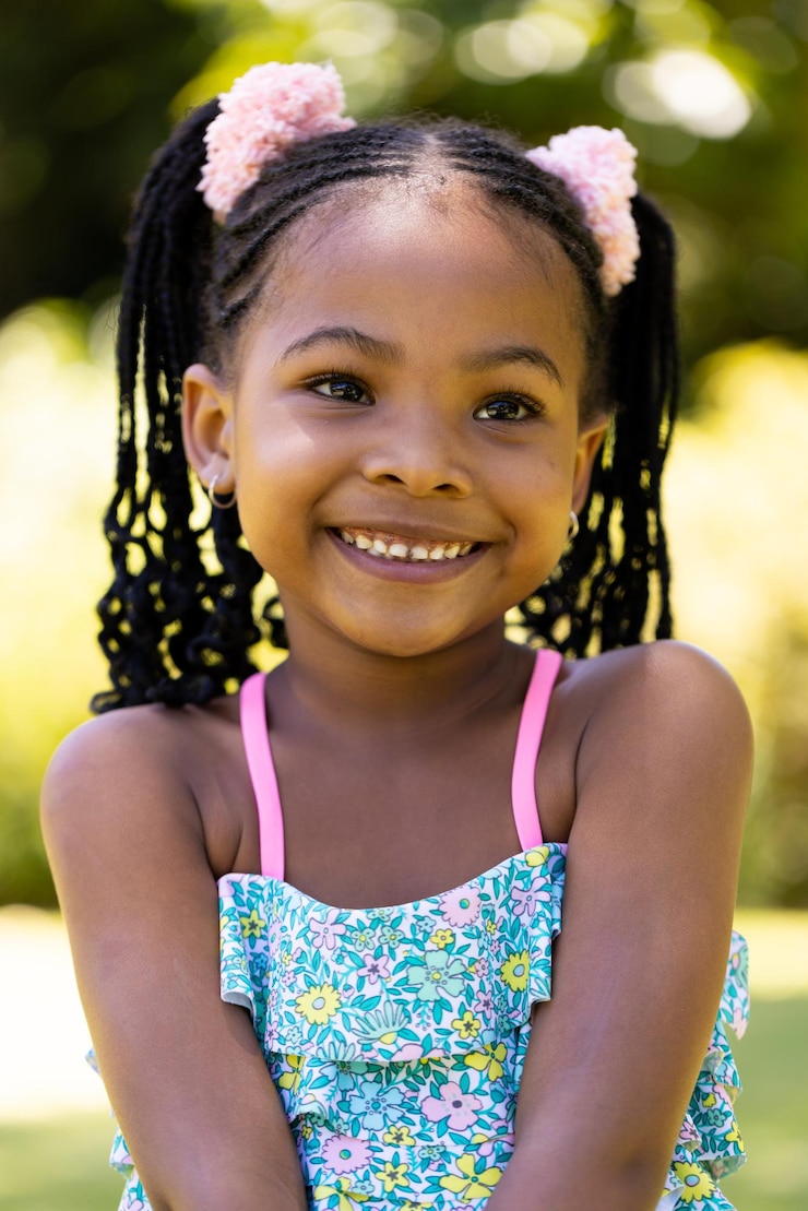 Photo portrait en gros plan d'une fille mignonne souriante afro-américaine avec des dreadlocks qui détourne le regard