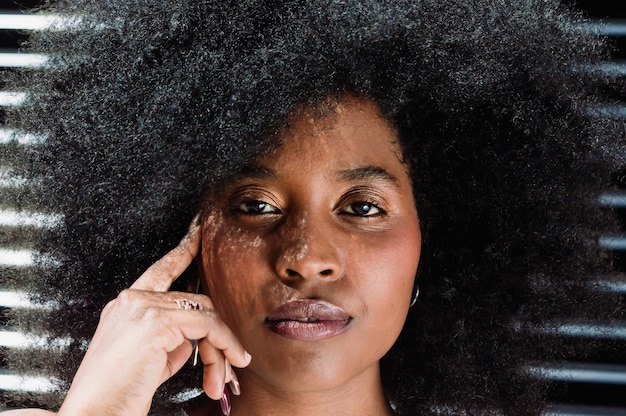 portrait en gros plan d'une fille noire avec afro regardant la caméra