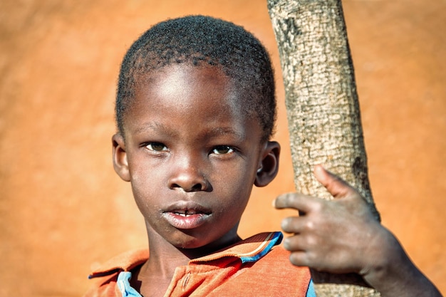 Photo portrait en gros plan d'un garçon debout près d'un arbre