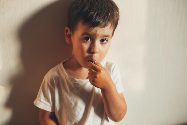 Portrait en gros plan d'un garçon regardant la caméra en mangeant des aliments sucrés aux bleuets des aliments sains