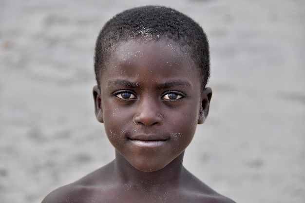 Portrait en gros plan d'un garçon sans chemise sur la plage