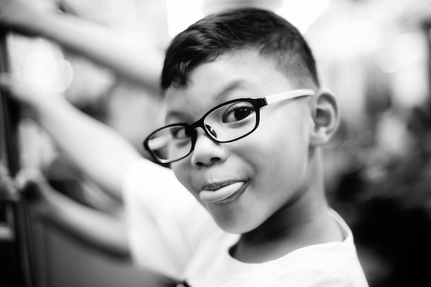 Photo portrait en gros plan d'un garçon souriant avec des lunettes