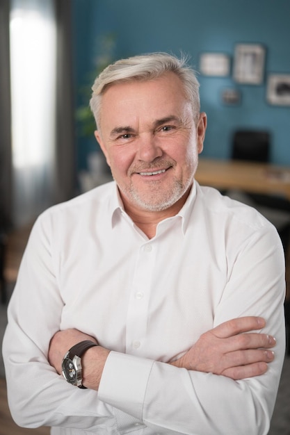 Portrait en gros plan d'un homme d'affaires aux cheveux gris matures et joyeux en bonne santé souriant à la caméra